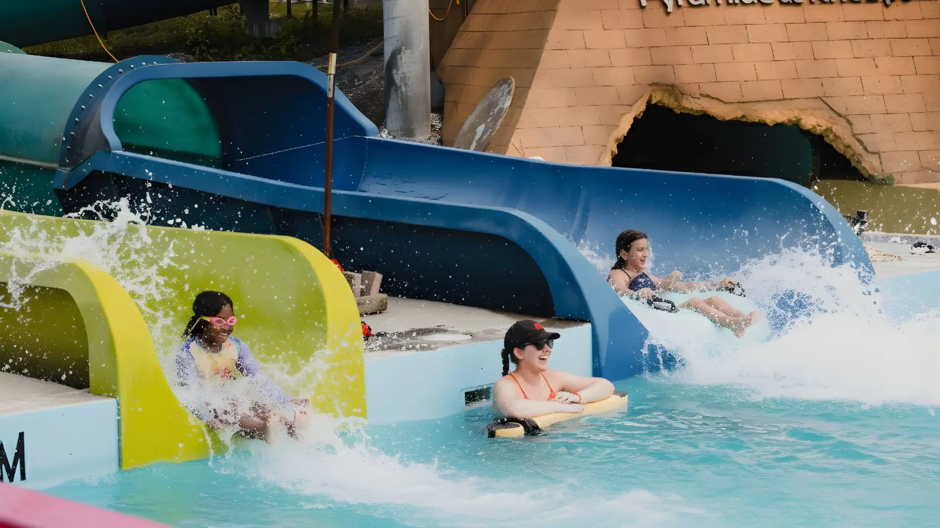 Enfants et adultes descendant des glissades d’eau colorées à l’Aquaparc Safari