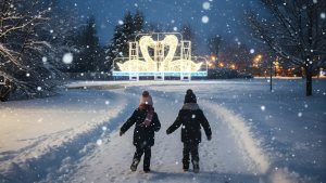 Enfants marchant dans la neige vers les illuminations de Féerie au Parc Safari, lors d’une visite hivernale de nuit.